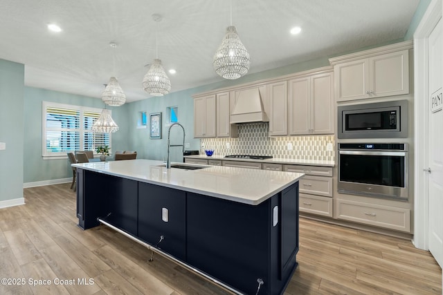 kitchen with stainless steel appliances, a sink, light countertops, backsplash, and custom range hood