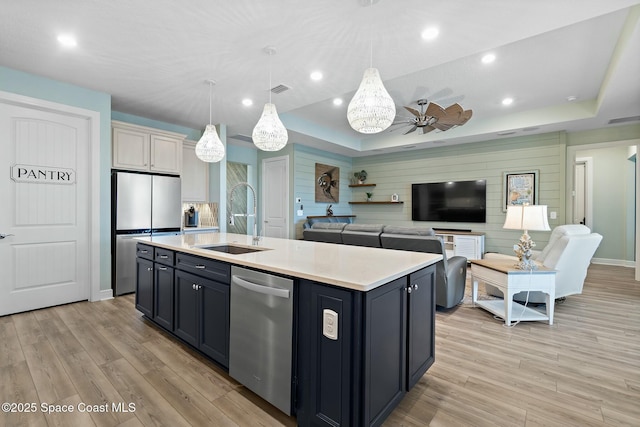 kitchen featuring visible vents, stainless steel appliances, light countertops, light wood-type flooring, and a sink