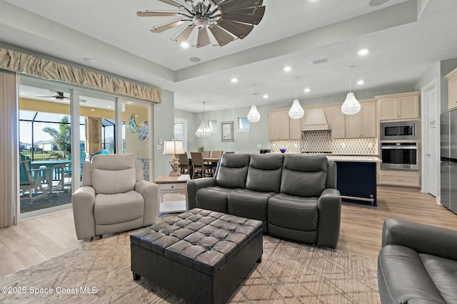 living area with recessed lighting, ceiling fan, and light wood finished floors