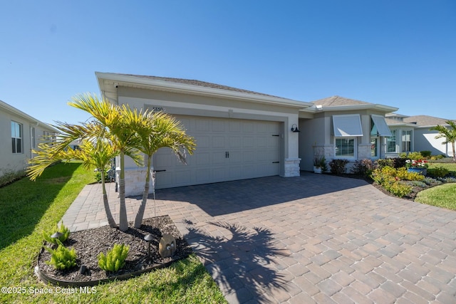 8850 Shoreline Ave, Melbourne, FL 32940 - view of front facade featuring stucco siding, a garage, decorative driveway, and stone siding