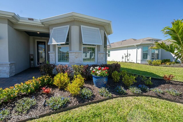 8850 Shoreline Ave, Melbourne, FL 32940 - property entrance featuring stucco siding, a yard, and stone siding