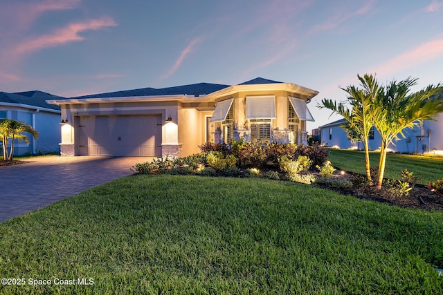 8850 Shoreline Ave, Melbourne, FL 32940 - view of front of property with decorative driveway, a garage, a lawn, and stucco siding