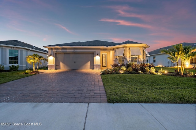 8850 Shoreline Ave, Melbourne, FL 32940 - view of front of property featuring decorative driveway, an attached garage, a lawn, and stucco siding