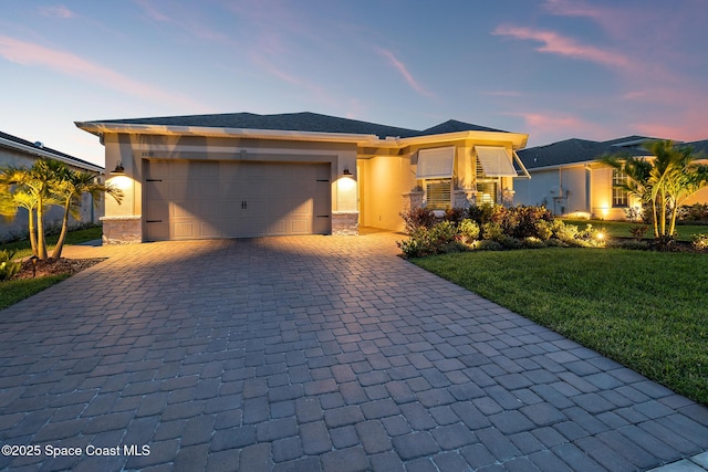 8850 Shoreline Ave, Melbourne, FL 32940 - view of front of property with decorative driveway, a garage, a lawn, and stucco siding