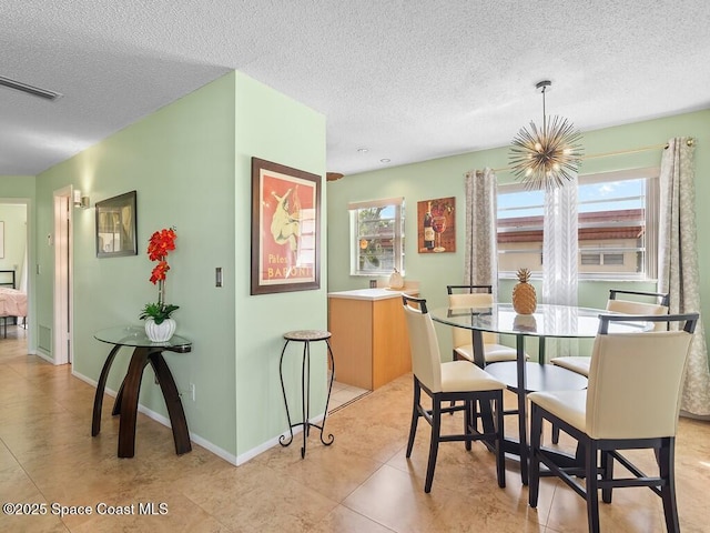 dining area with light tile patterned floors, baseboards, visible vents, and a textured ceiling