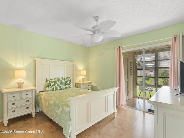 bedroom with access to exterior, ceiling fan, and a textured ceiling