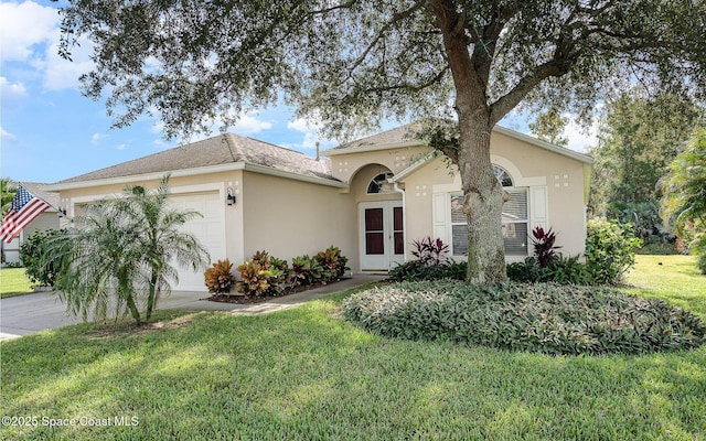 single story home featuring an attached garage, a shingled roof, concrete driveway, stucco siding, and a front lawn