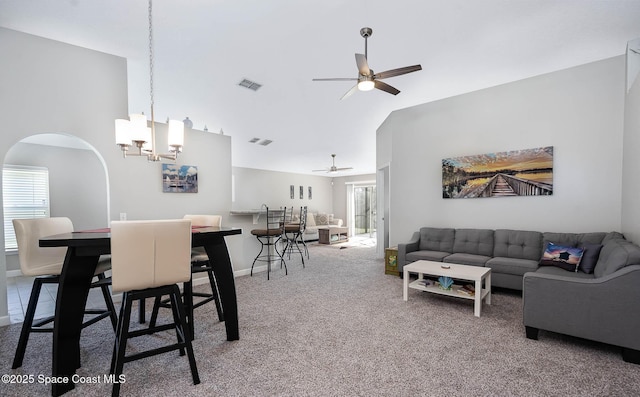 living area featuring carpet, high vaulted ceiling, plenty of natural light, and visible vents