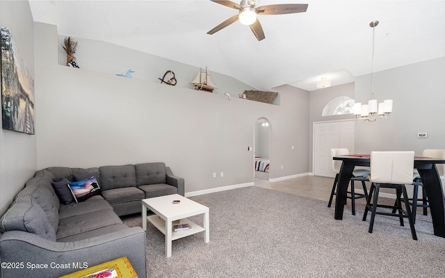 living room with arched walkways, baseboards, light colored carpet, vaulted ceiling, and ceiling fan with notable chandelier