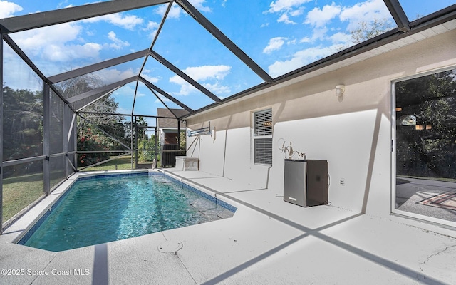 outdoor pool with a patio and glass enclosure