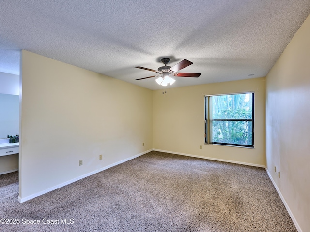 carpeted spare room with ceiling fan, a textured ceiling, and baseboards