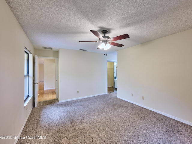 carpeted empty room featuring visible vents and baseboards