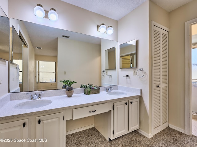 full bath with a closet, visible vents, a sink, and double vanity