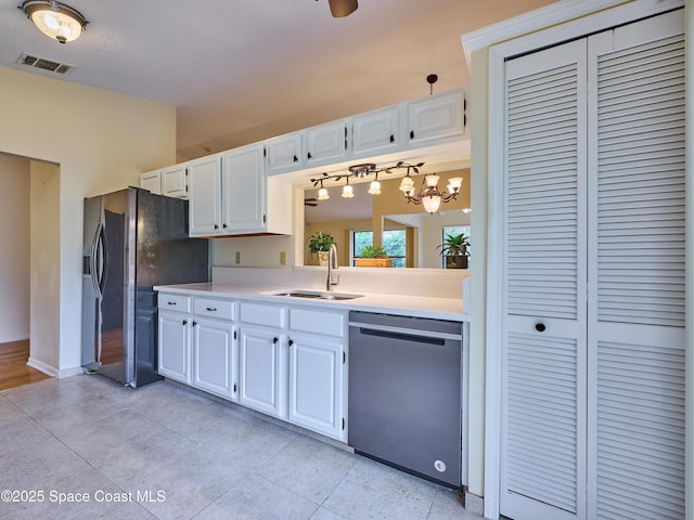 kitchen with light countertops, appliances with stainless steel finishes, a sink, and visible vents