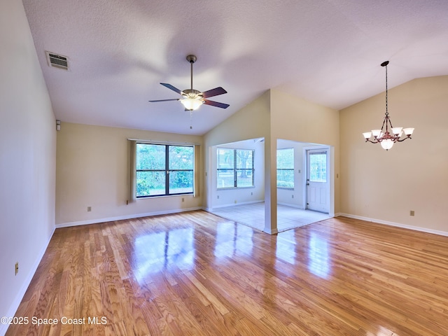 unfurnished living room featuring lofted ceiling, light wood-style floors, visible vents, and a textured ceiling