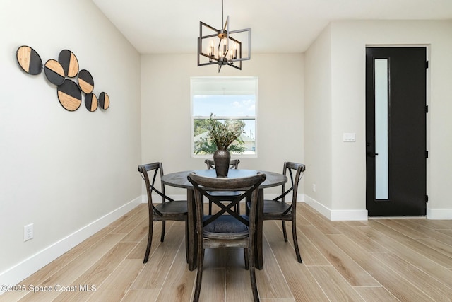 dining area with a notable chandelier, wood finish floors, and baseboards