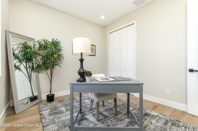 office featuring light wood-style flooring, visible vents, and baseboards