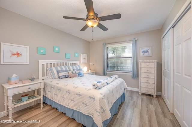 bedroom featuring light wood-style floors, a closet, ceiling fan, and baseboards