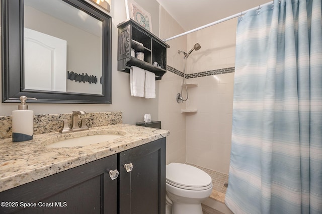 bathroom featuring tiled shower, vanity, and toilet