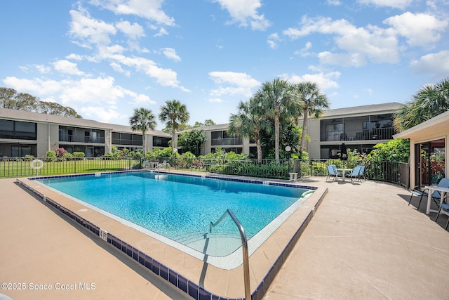 community pool with fence and a patio