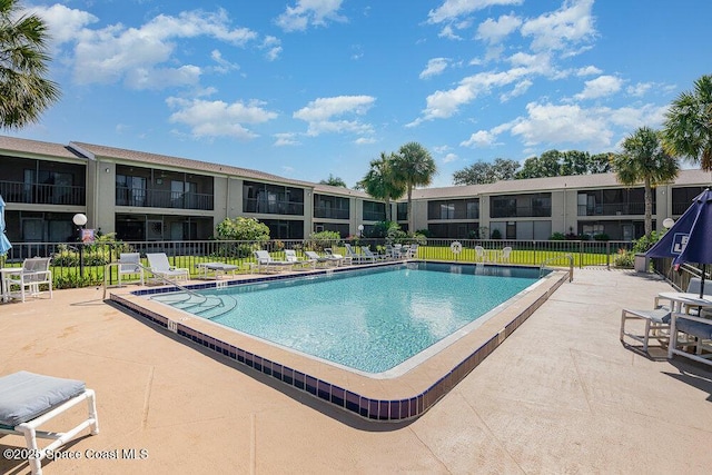 pool with fence and a patio