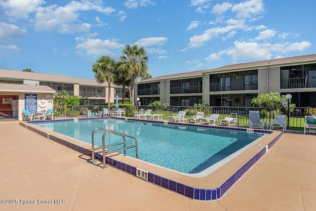 community pool with fence and a patio