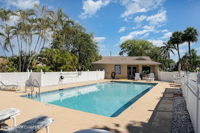 community pool featuring a fenced backyard and a patio