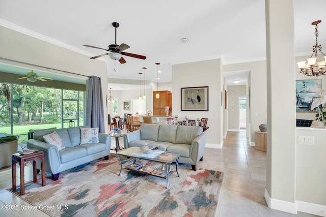 living area featuring ceiling fan with notable chandelier, ornamental molding, light tile patterned floors, and baseboards