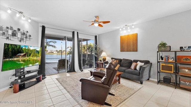 living area featuring a ceiling fan, baseboards, track lighting, and light tile patterned floors