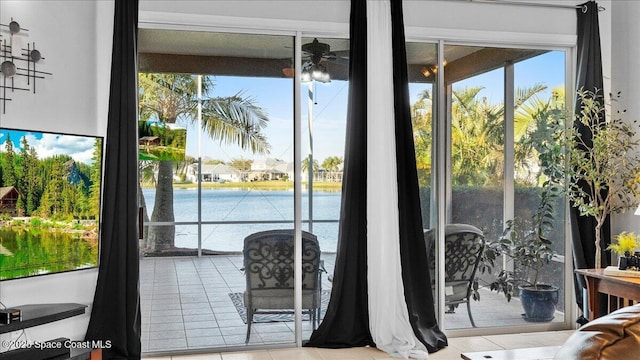 doorway to outside featuring ceiling fan, tile patterned floors, and a healthy amount of sunlight