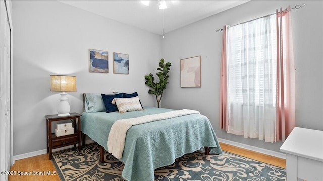 bedroom with light wood-type flooring and baseboards