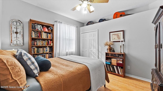 bedroom with light wood-style floors, a closet, ceiling fan, and baseboards