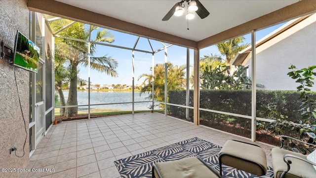 sunroom / solarium with a water view and a ceiling fan