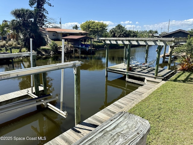 dock area featuring a water view and a lawn