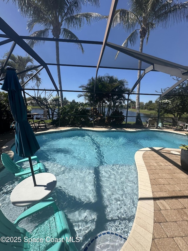 outdoor pool with glass enclosure and a patio area