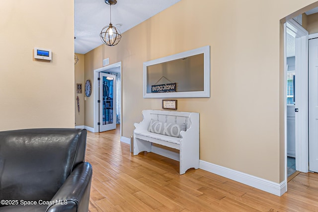 hall with baseboards and light wood-style floors