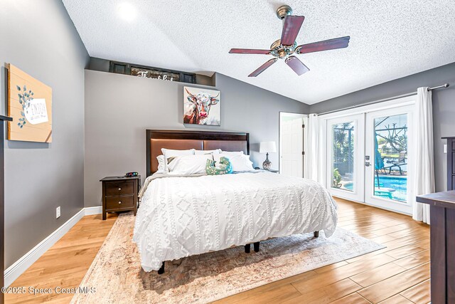 bedroom with light wood-type flooring, access to outside, french doors, baseboards, and vaulted ceiling