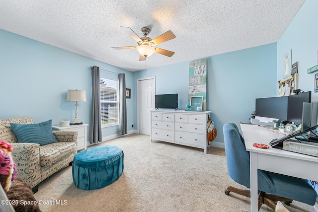 carpeted office featuring baseboards, a textured ceiling, and a ceiling fan