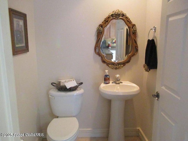 bathroom featuring baseboards and toilet