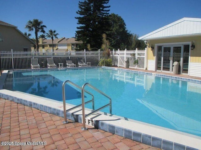 pool with a patio area and fence