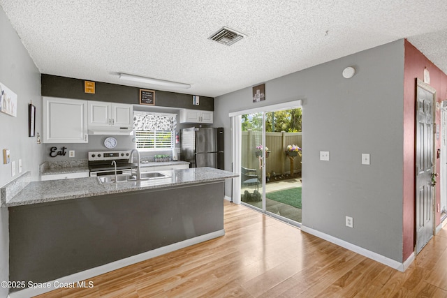 kitchen featuring under cabinet range hood, a sink, white cabinetry, visible vents, and appliances with stainless steel finishes