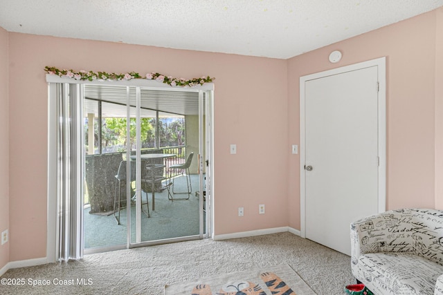 interior space with a textured ceiling and baseboards