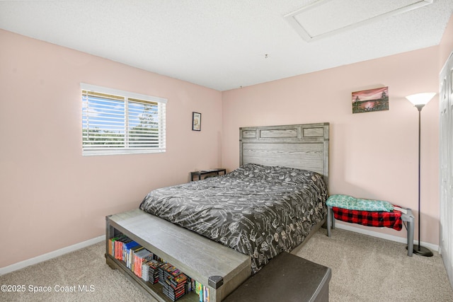 bedroom featuring carpet, attic access, and baseboards