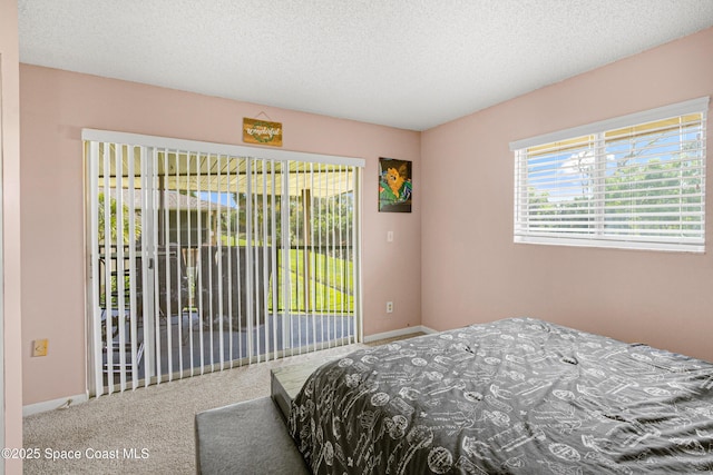 carpeted bedroom with access to exterior, a textured ceiling, and baseboards