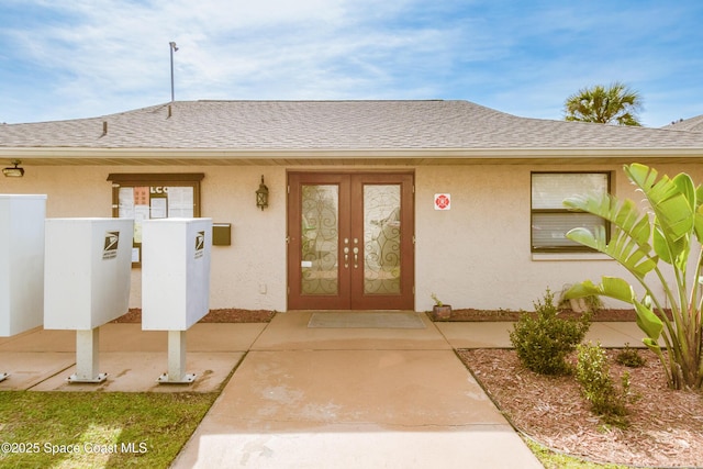 doorway to property featuring french doors, roof with shingles, and stucco siding