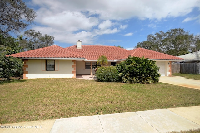 view of front facade with a garage, a tiled roof, stucco siding, a chimney, and a front yard