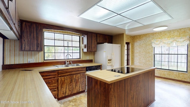 kitchen featuring wallpapered walls, black electric cooktop, white fridge with ice dispenser, wooden counters, and a sink