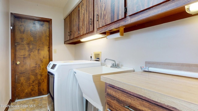 washroom featuring independent washer and dryer, a sink, and cabinet space