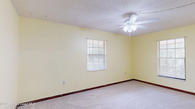 unfurnished room featuring light colored carpet, plenty of natural light, and baseboards