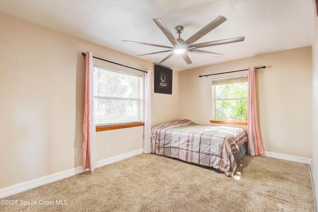 carpeted bedroom with a ceiling fan and baseboards